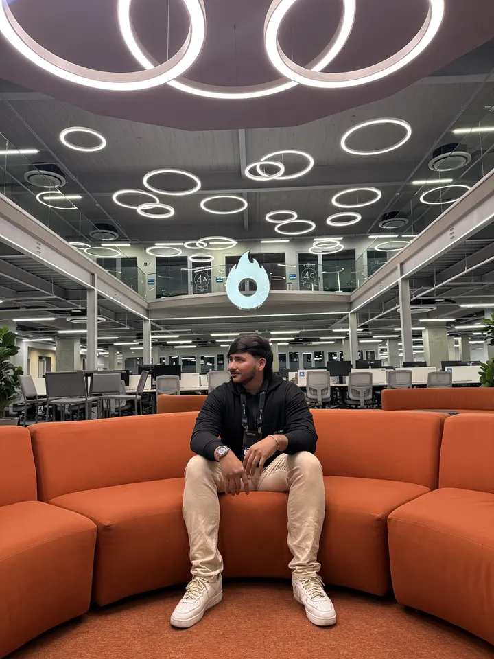 Santiago Rengifo sentado en un sofá naranja en las oficinas de Hotmart en Brasil